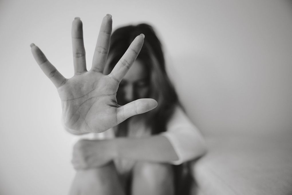 Persona sfocata con una mano tesa a coprire la telecamera, scena in bianco e nero