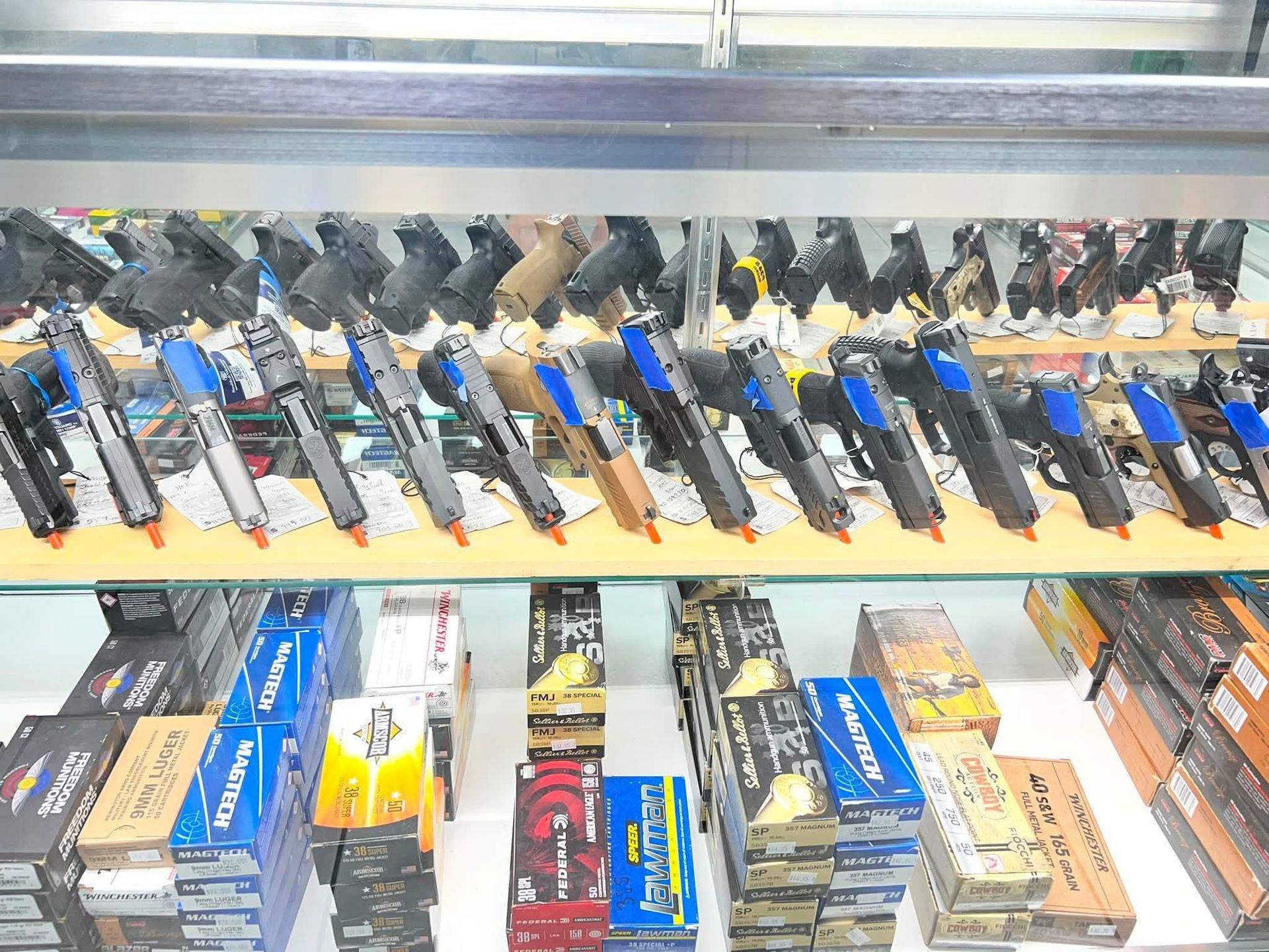 Display case of assorted pistols and boxed handguns on store shelves