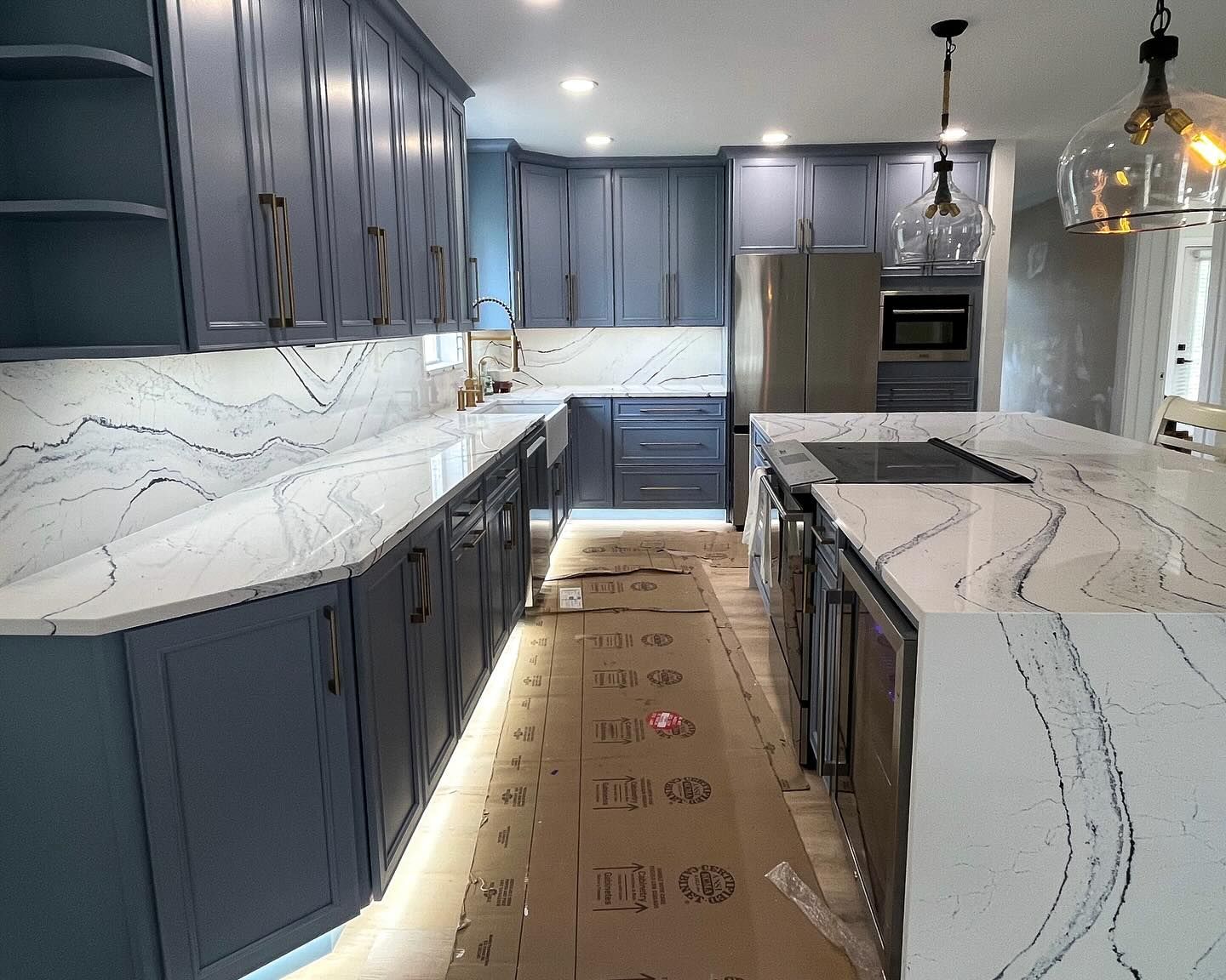 Blue kitchen with white countertops and island.