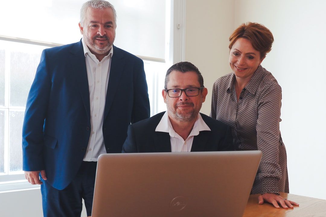 the directors of england and company looking at a laptop