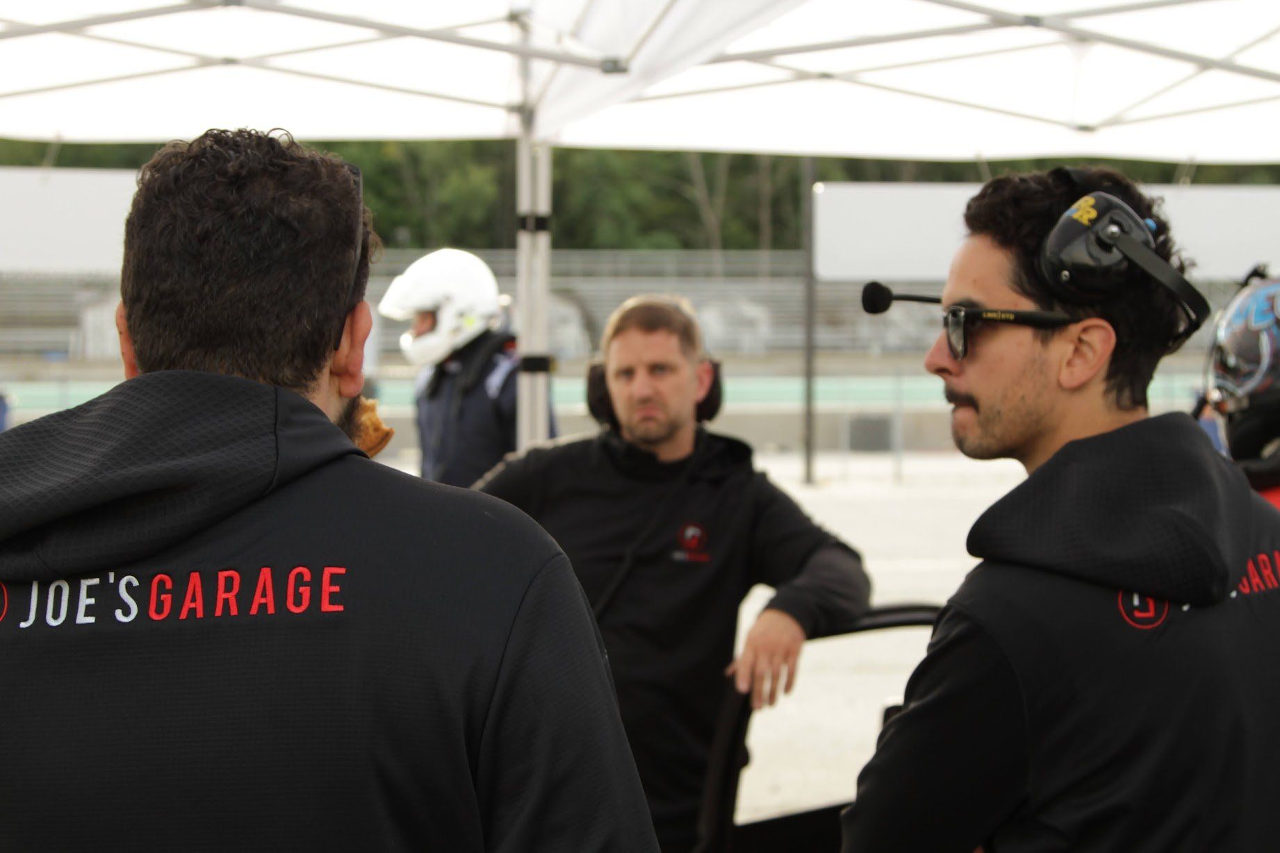 Three men in black hoodies with 