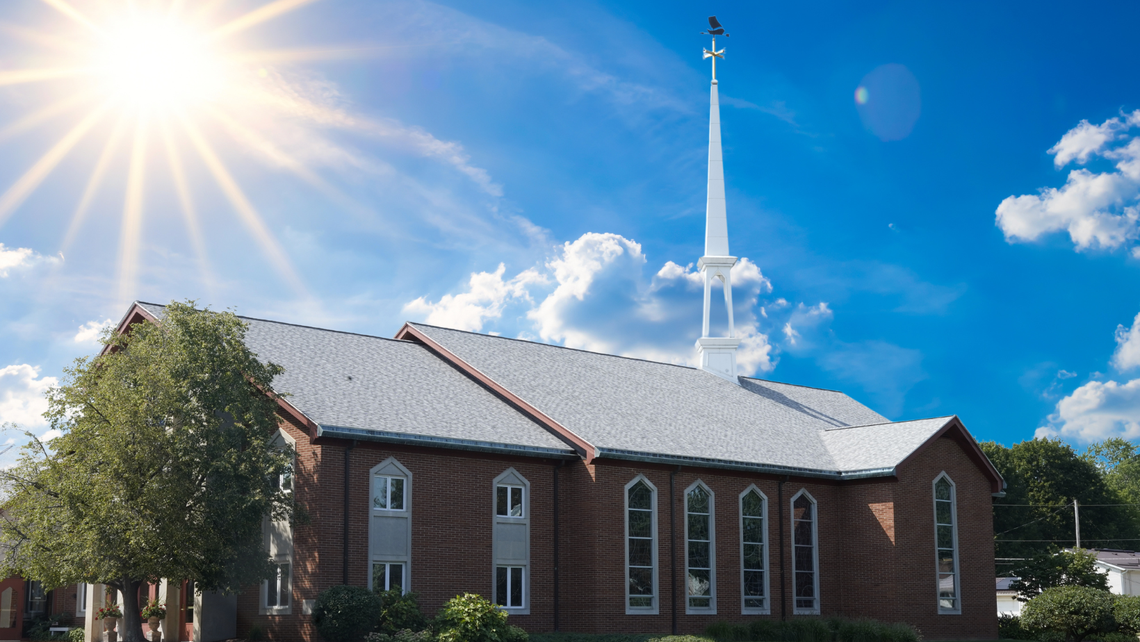 A church with the sun shining through the clouds