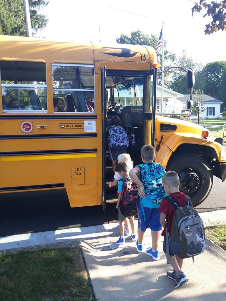 A group of children are getting on a school bus