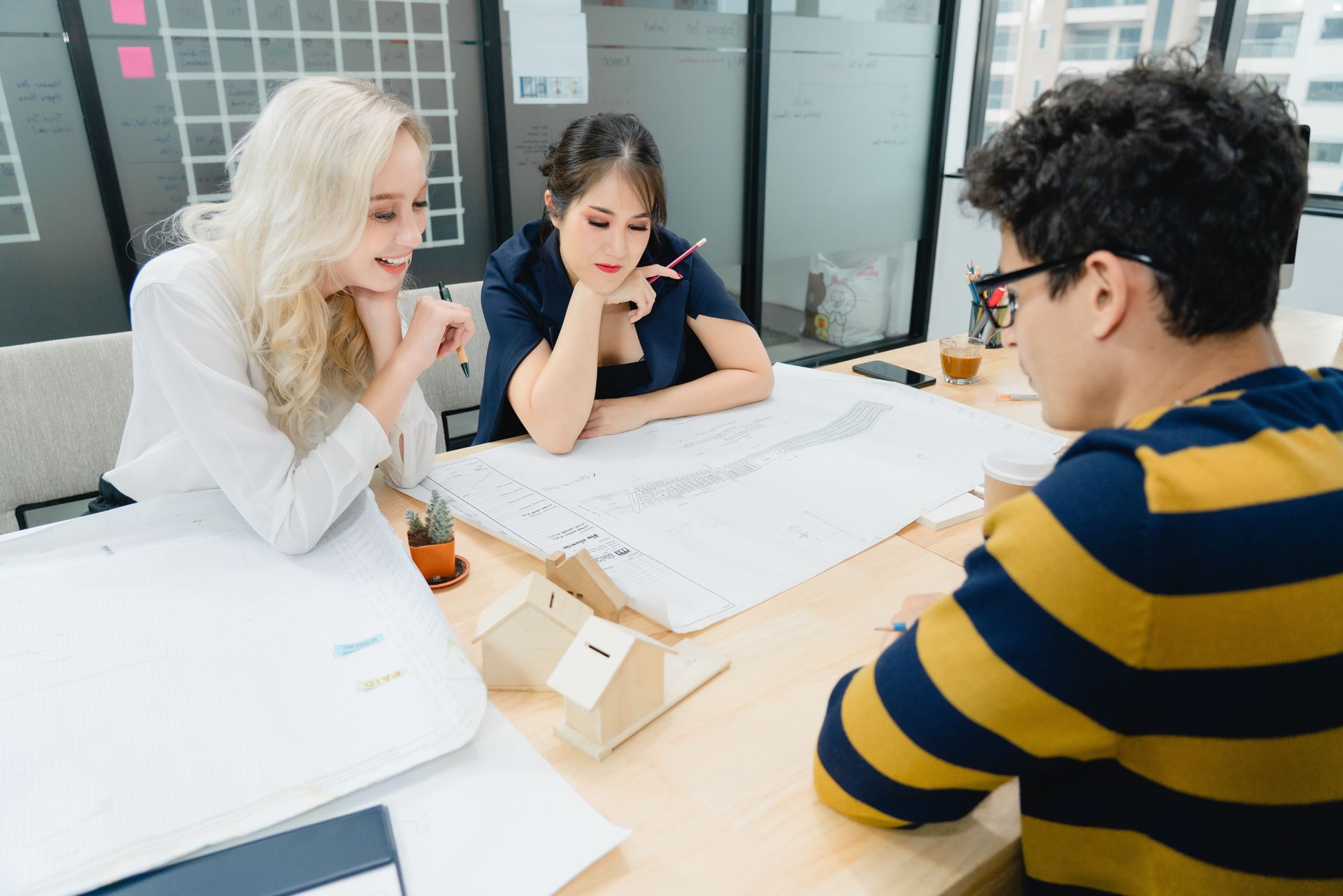 Three diverse colleagues are focused and engaged, performing a design and drafting service. Three diverse colleagues are focused and engaged, performing a design and drafting service.