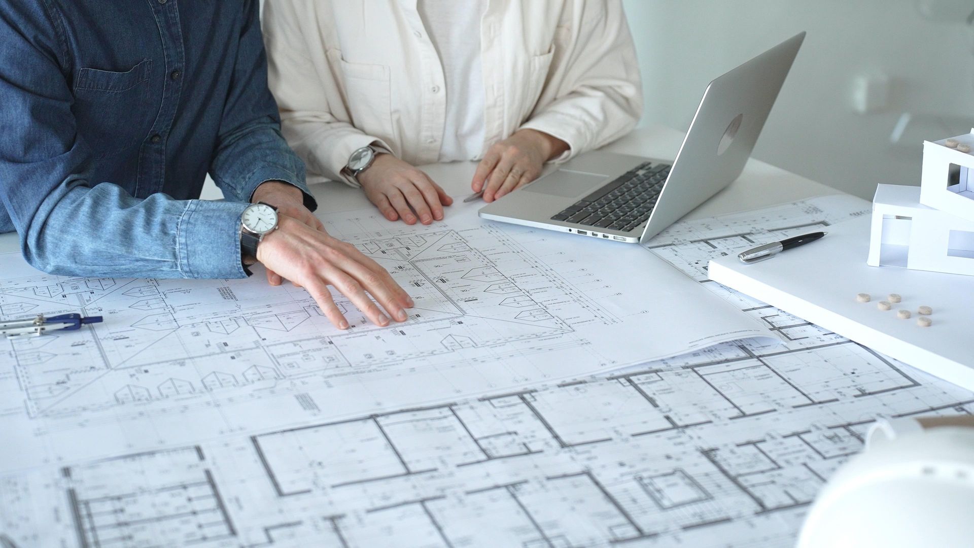Two workers are discussing a blueprint.