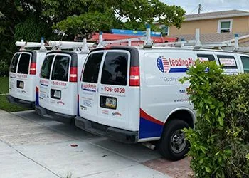 Three leading plumbing vans are parked in a driveway.