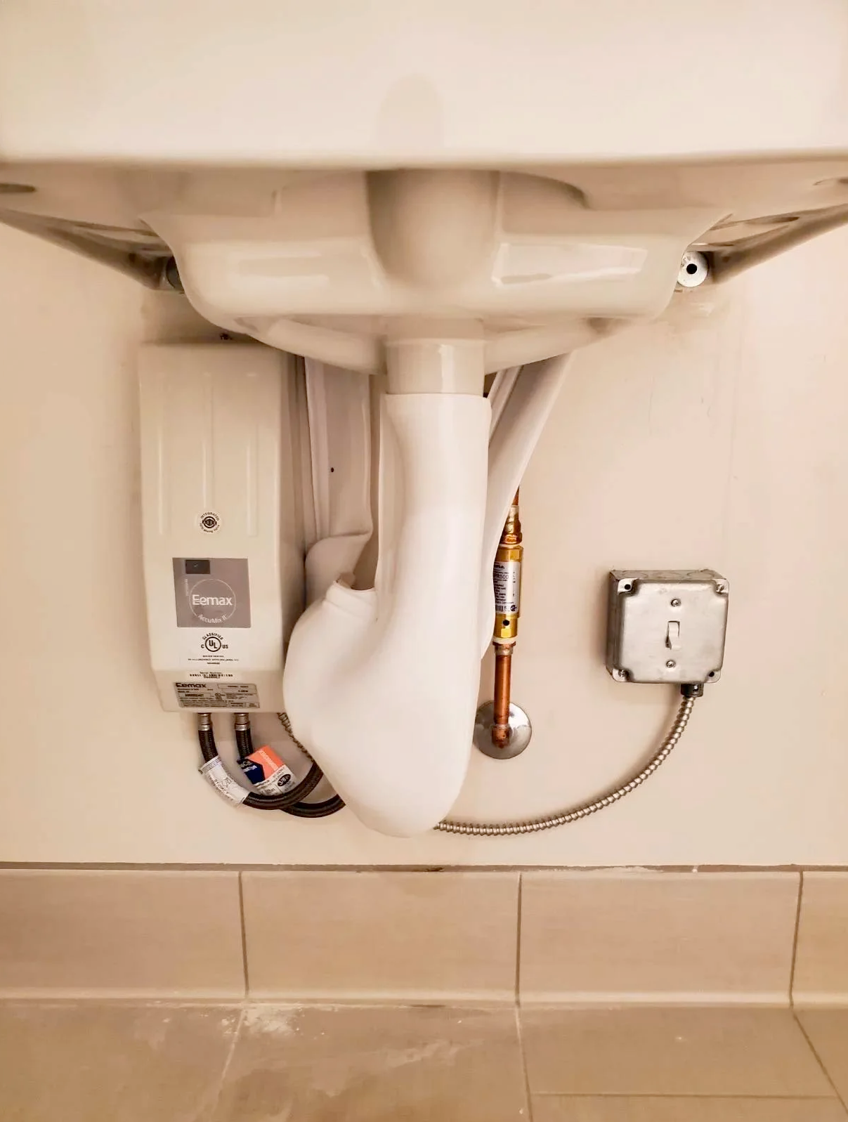 A bathroom sink with a water heater attached to it.