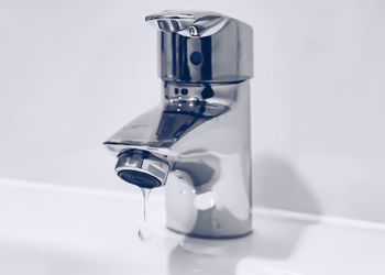 A close up of a faucet with water dripping out of it.