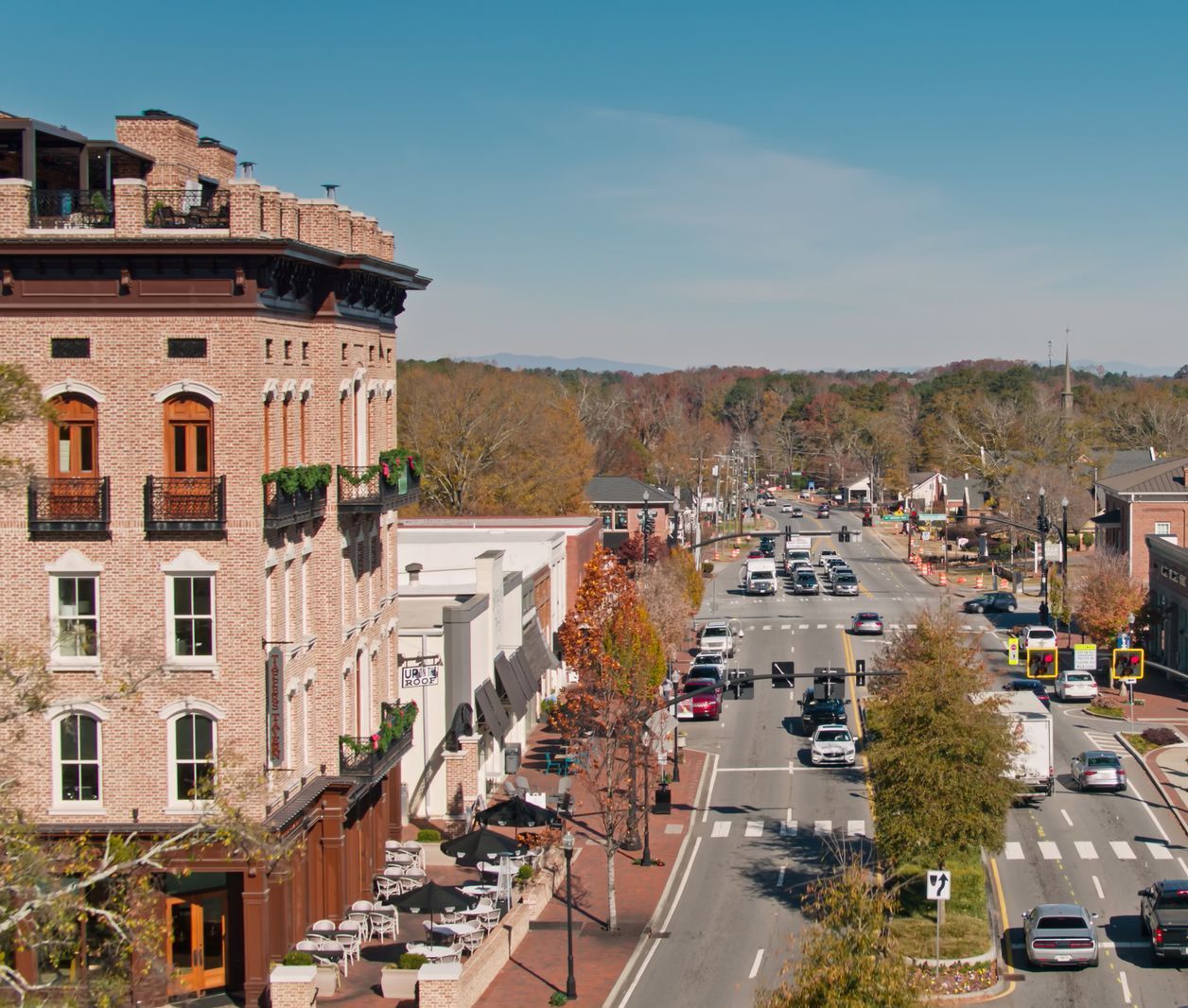 Brick building and road with cars in a town on a sunny day.