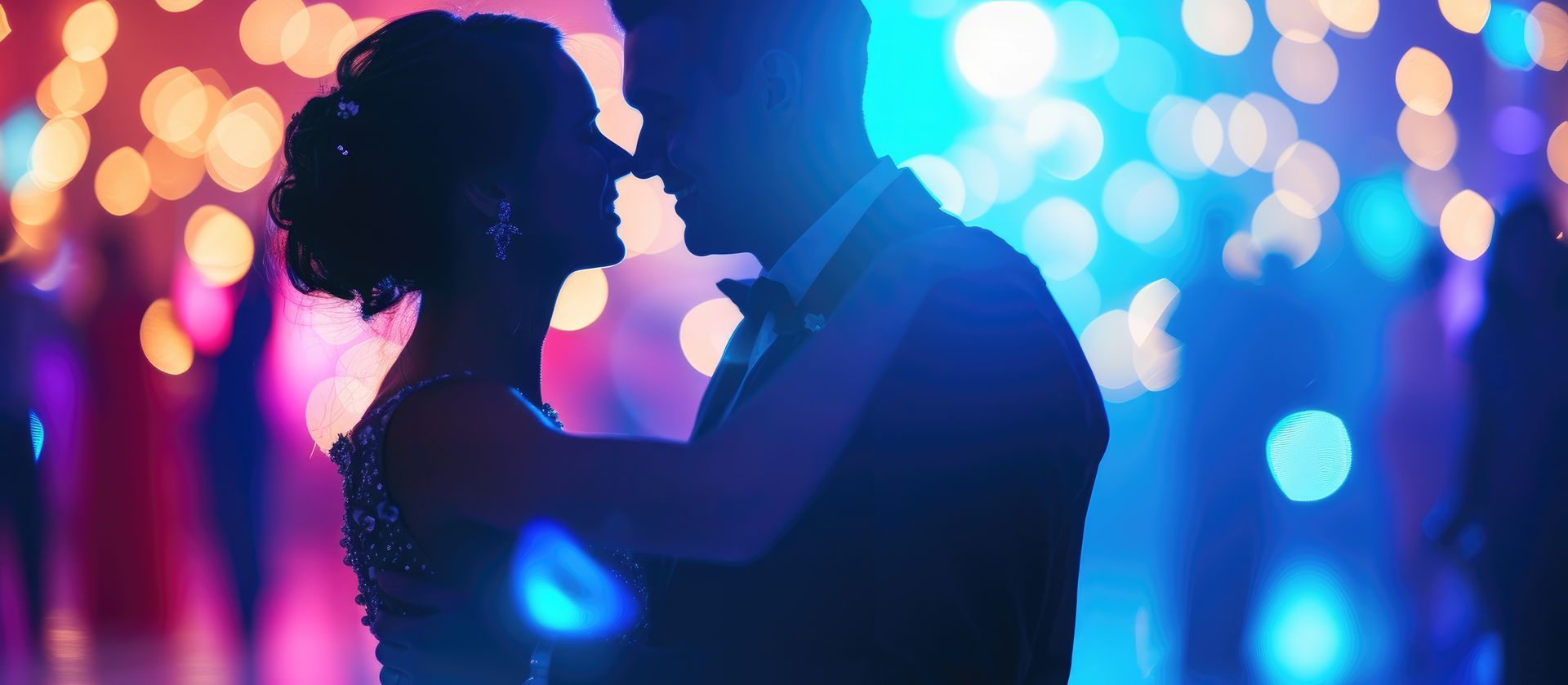 Silhouetted wedding couple dancing closely in a neon-lit venue with blue and pink lighting
