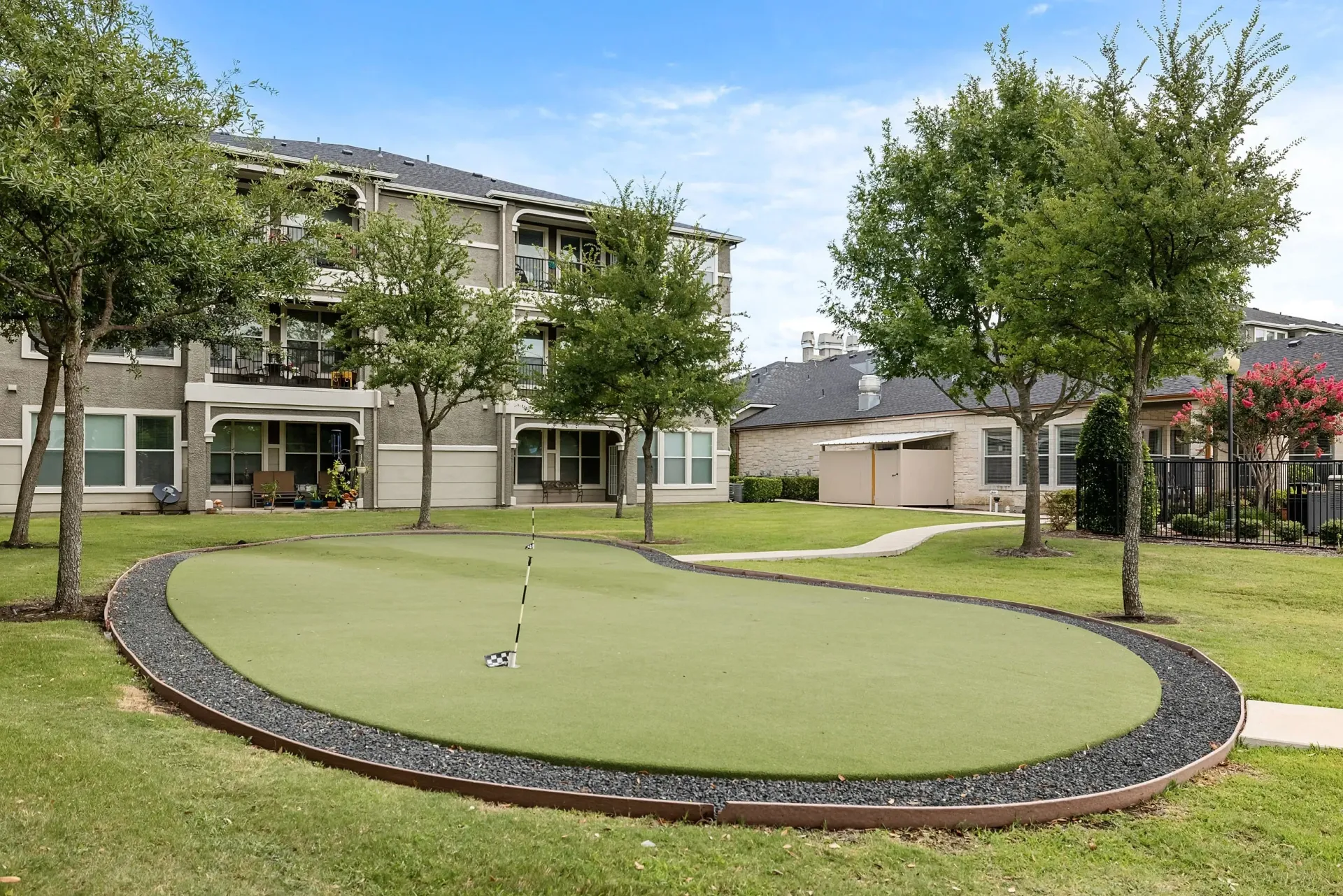 Putting green with flagstick at apartment complex.