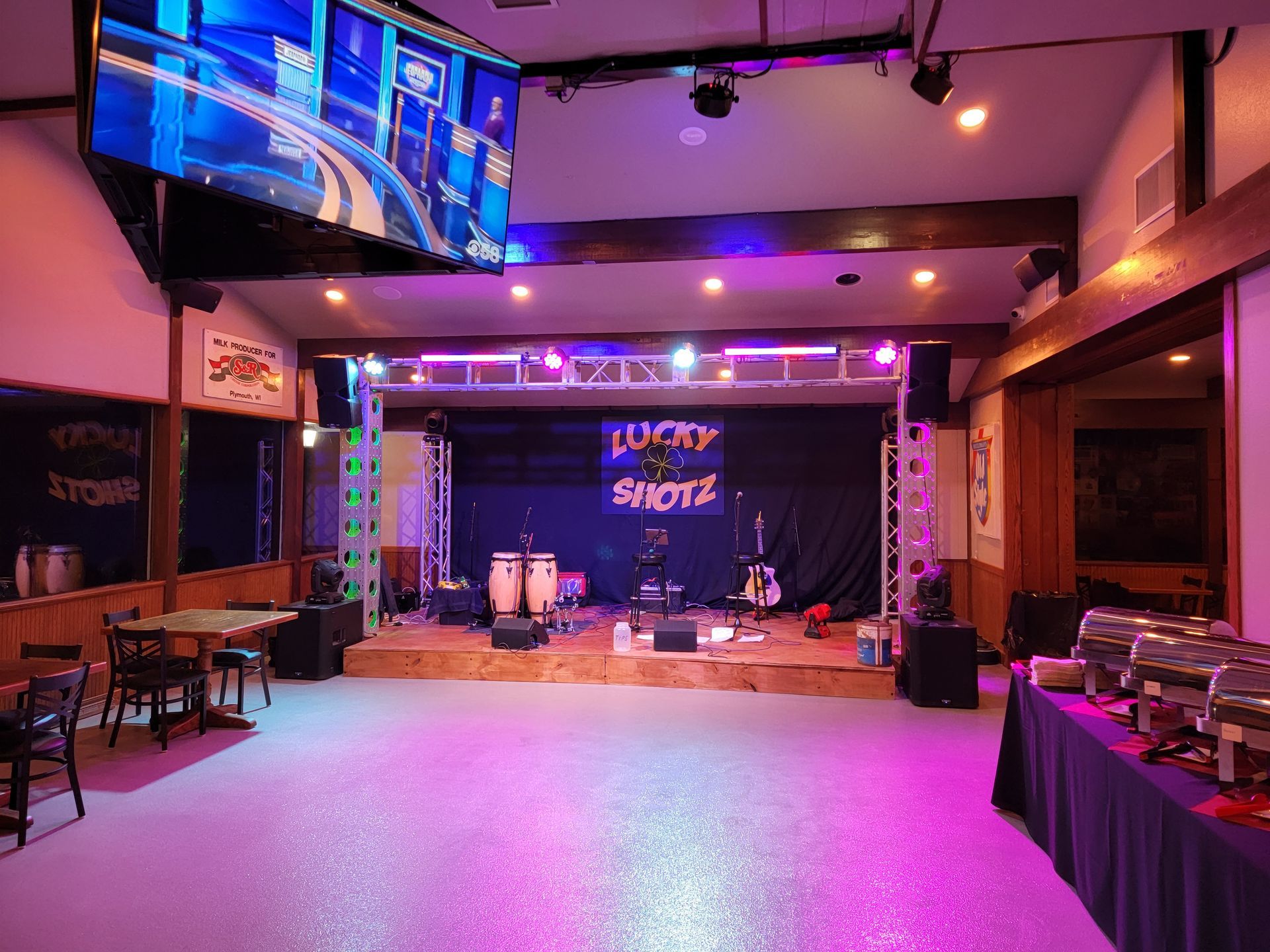 A large room with a stage and a buffet table.