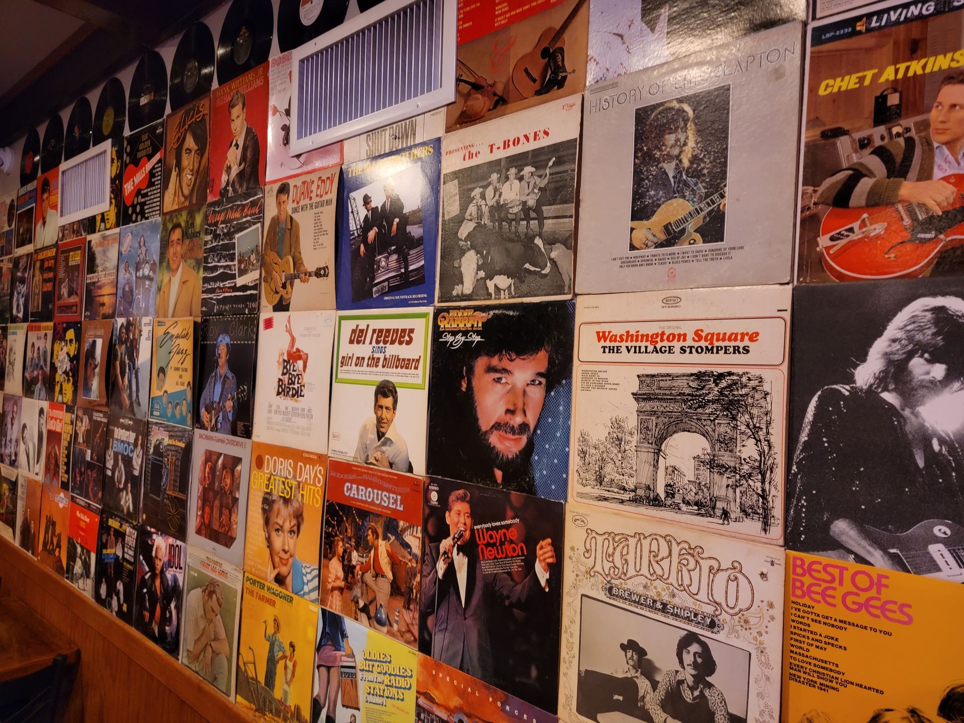 A wall covered in posters including one that says best of the eagles