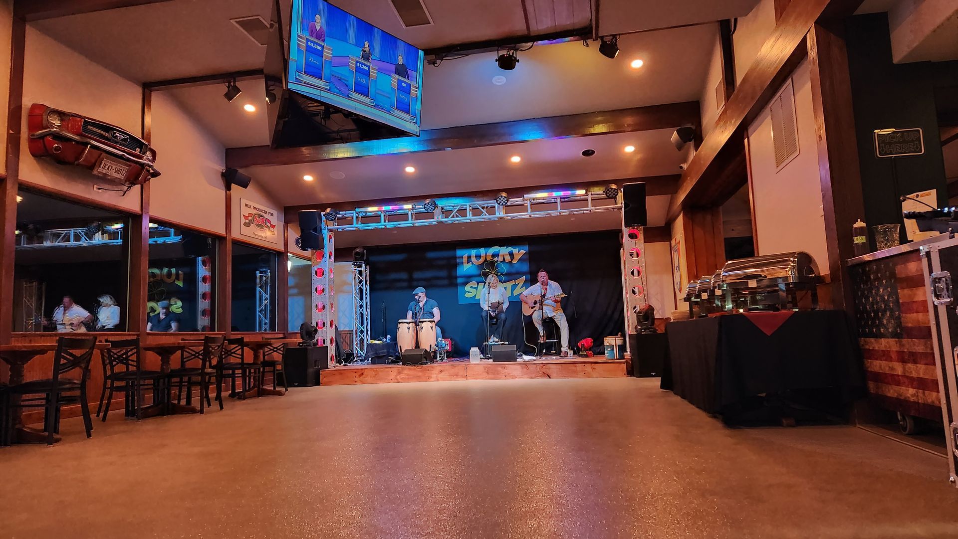 A large empty room with a stage and a band on it.