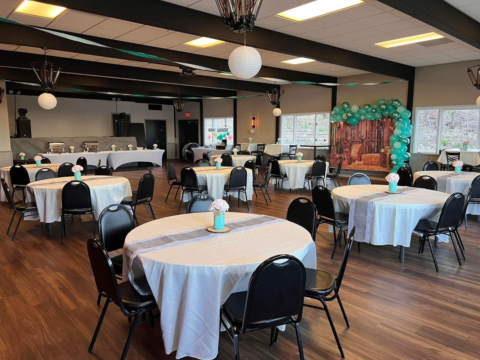 A large room with tables and chairs set up for a party.