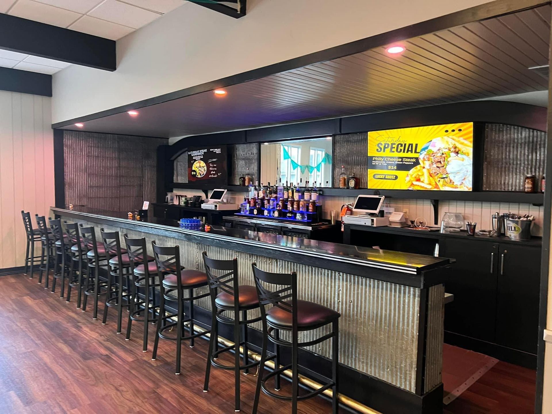 A long bar with a lot of stools in a restaurant.