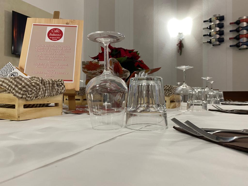 Apparecchiatura del tavolo del ristorante con bicchieri, posate, cartello e cassa di legno.