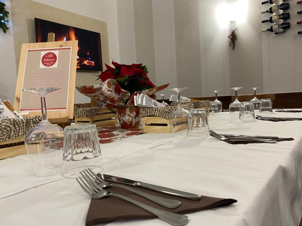 Elegante tavolo da ristorante apparecchiato per un pasto, con bicchieri da vino, posate e decorazioni.