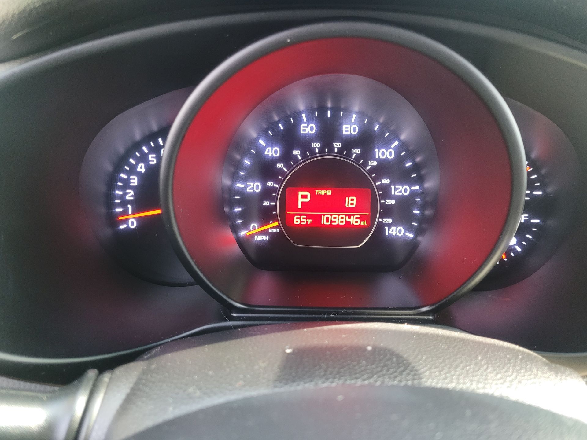 A close up of a car 's dashboard with a red p on it