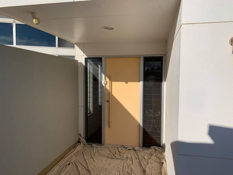 A Yellow Door is Sitting in the Middle of a Building — Holster Painting Contractors In Port Macquarie, NSW 