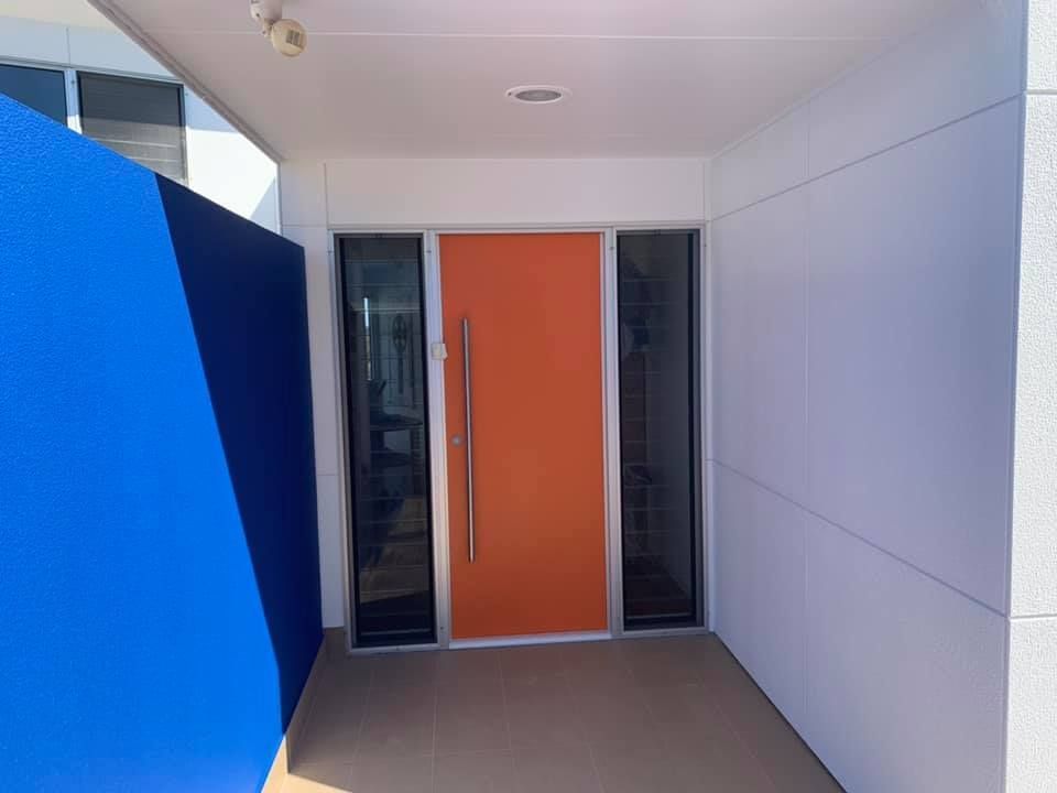 An Orange Door is Surrounded by Blue and White Walls — Holster Painting Contractors In Port Macquarie, NSW 