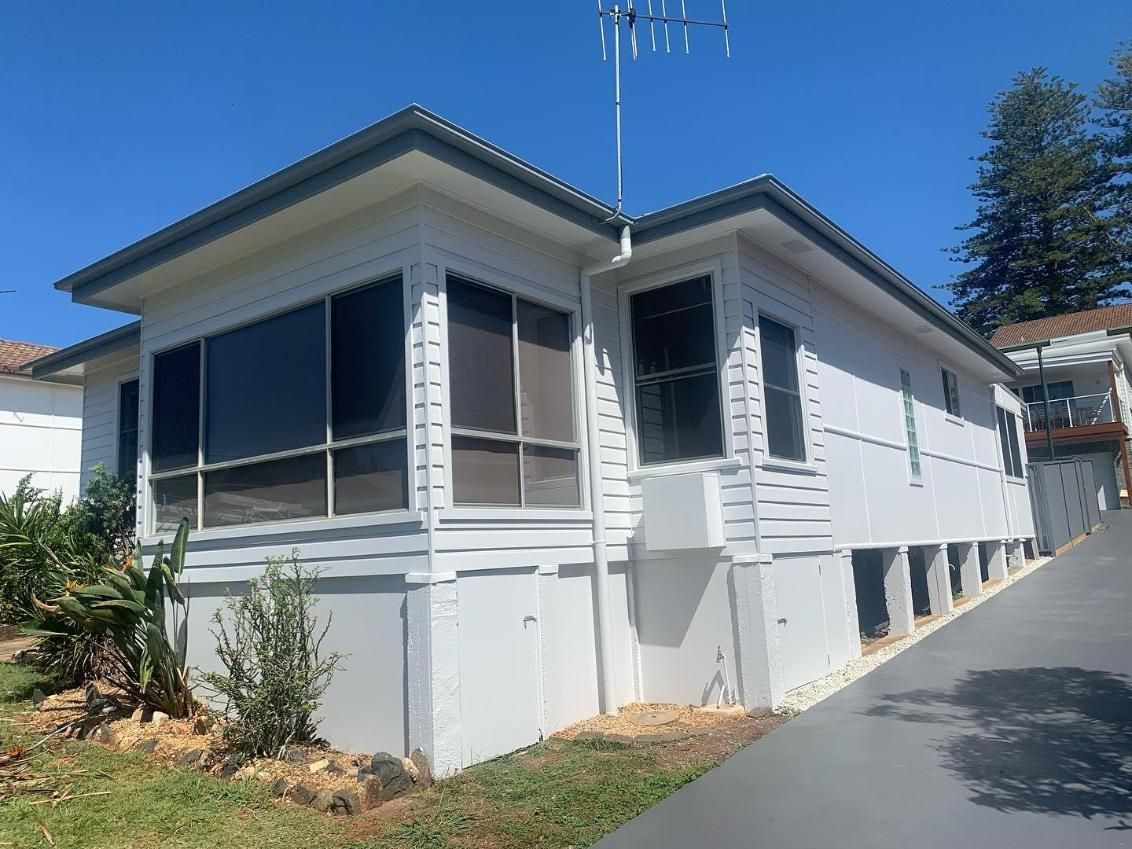 A White House With a Lot of Windows is Sitting on Top of a Hill — Holster Painting Contractors In Port Macquarie, NSW 