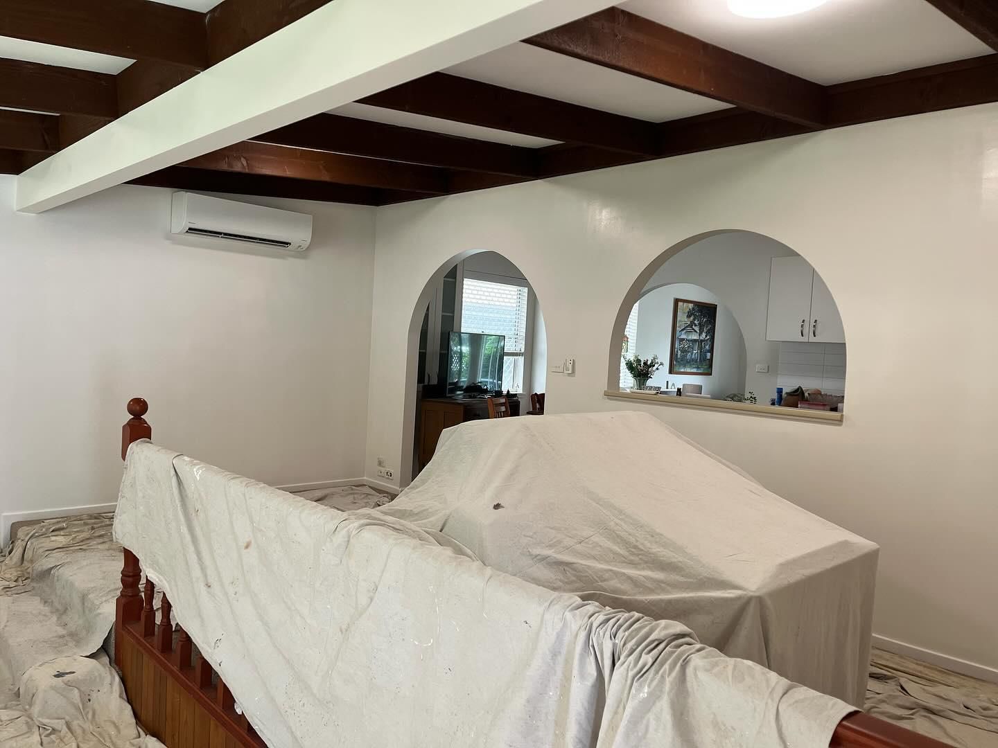 A Living Room With a Couch Covered in a White Cloth — Holster Painting Contractors In Port Macquarie, NSW