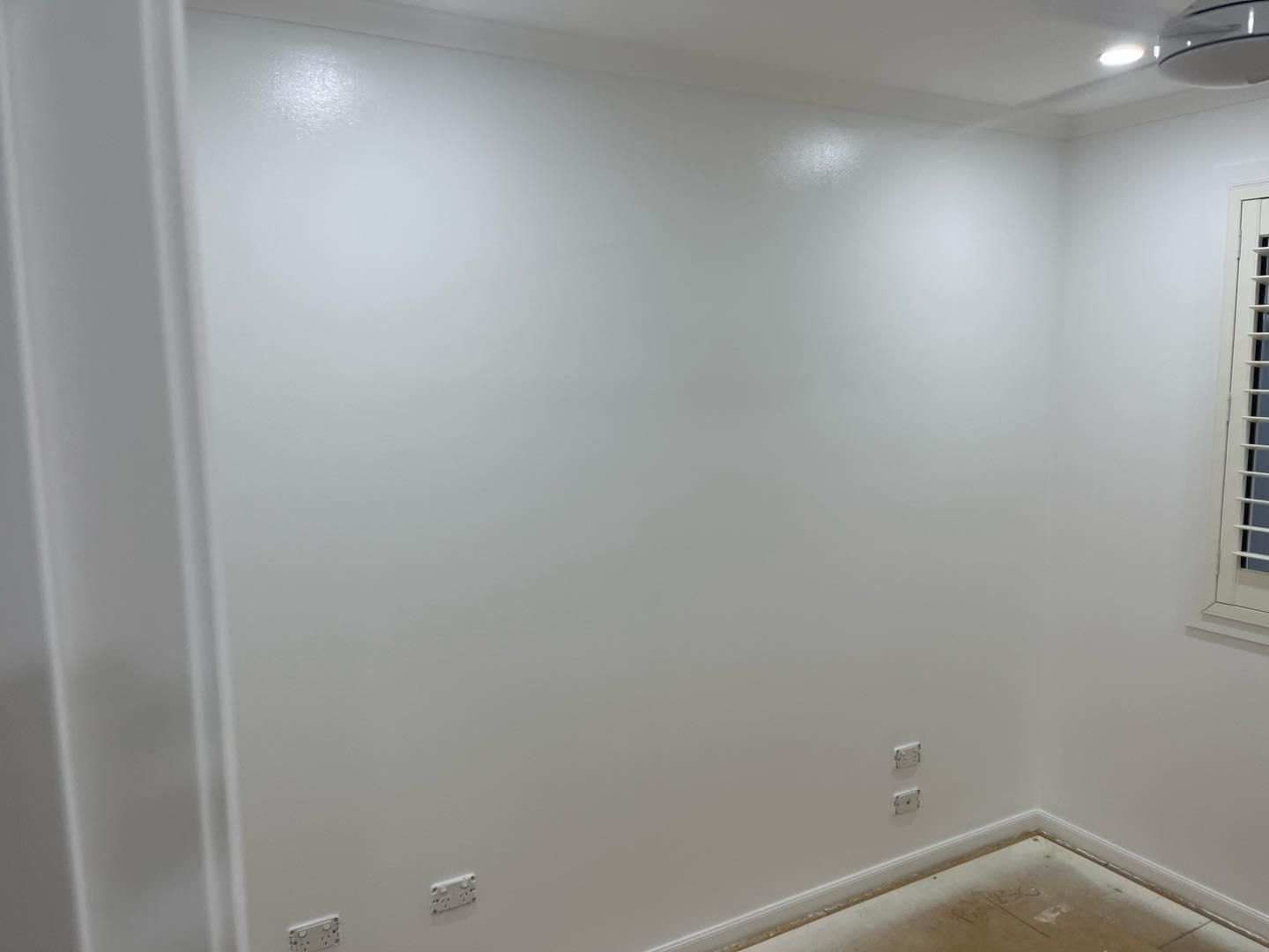 A Bedroom With White Walls and a Ceiling Fan — Holster Painting Contractors In Port Macquarie, NSW