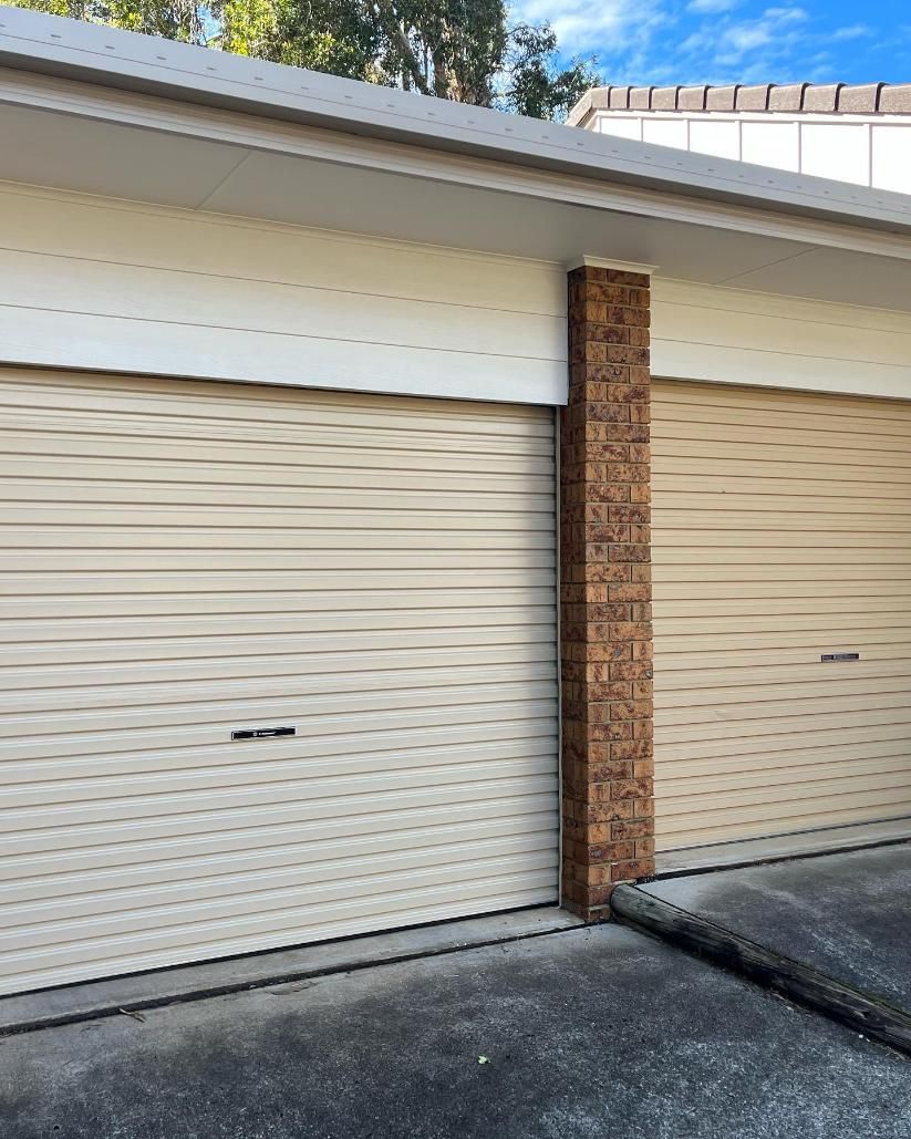 A White Garage Door With a Brick Pillar in Front of It — Holster Painting Contractors In Port Macquarie, NSW