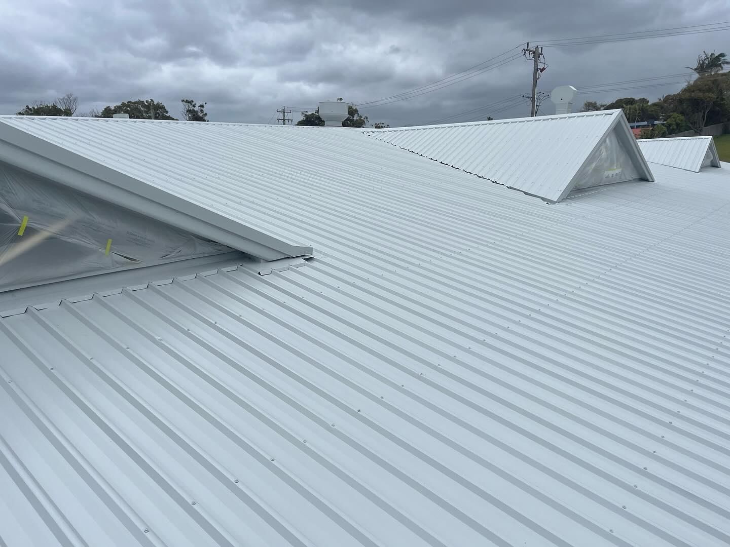 A White Metal Roof With a Cloudy Sky in the Background — Holster Painting Contractors In Port Macquarie, NSW