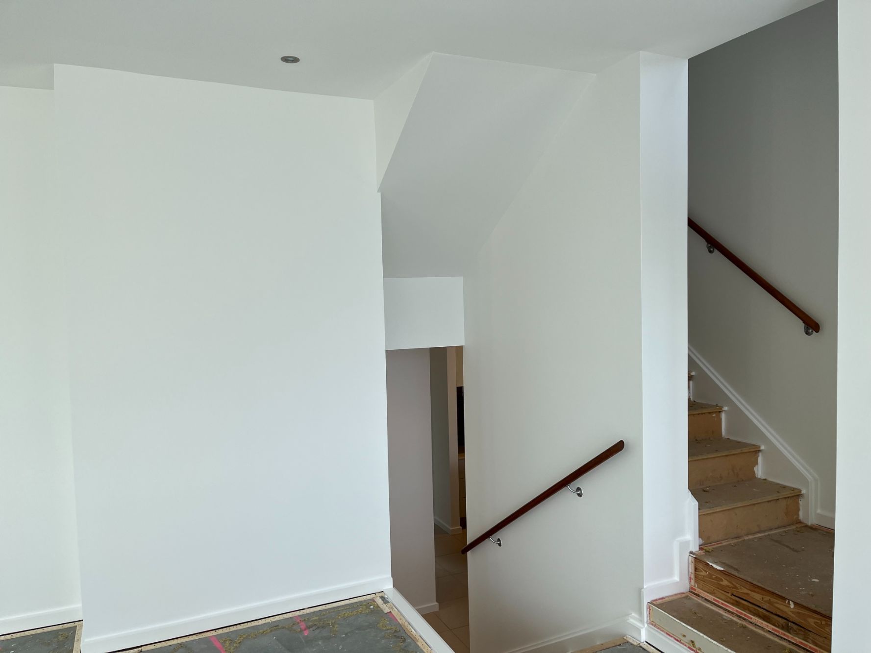 An Empty Room With Stairs and a Wooden Railing — Holster Painting Contractors In Port Macquarie, NSW