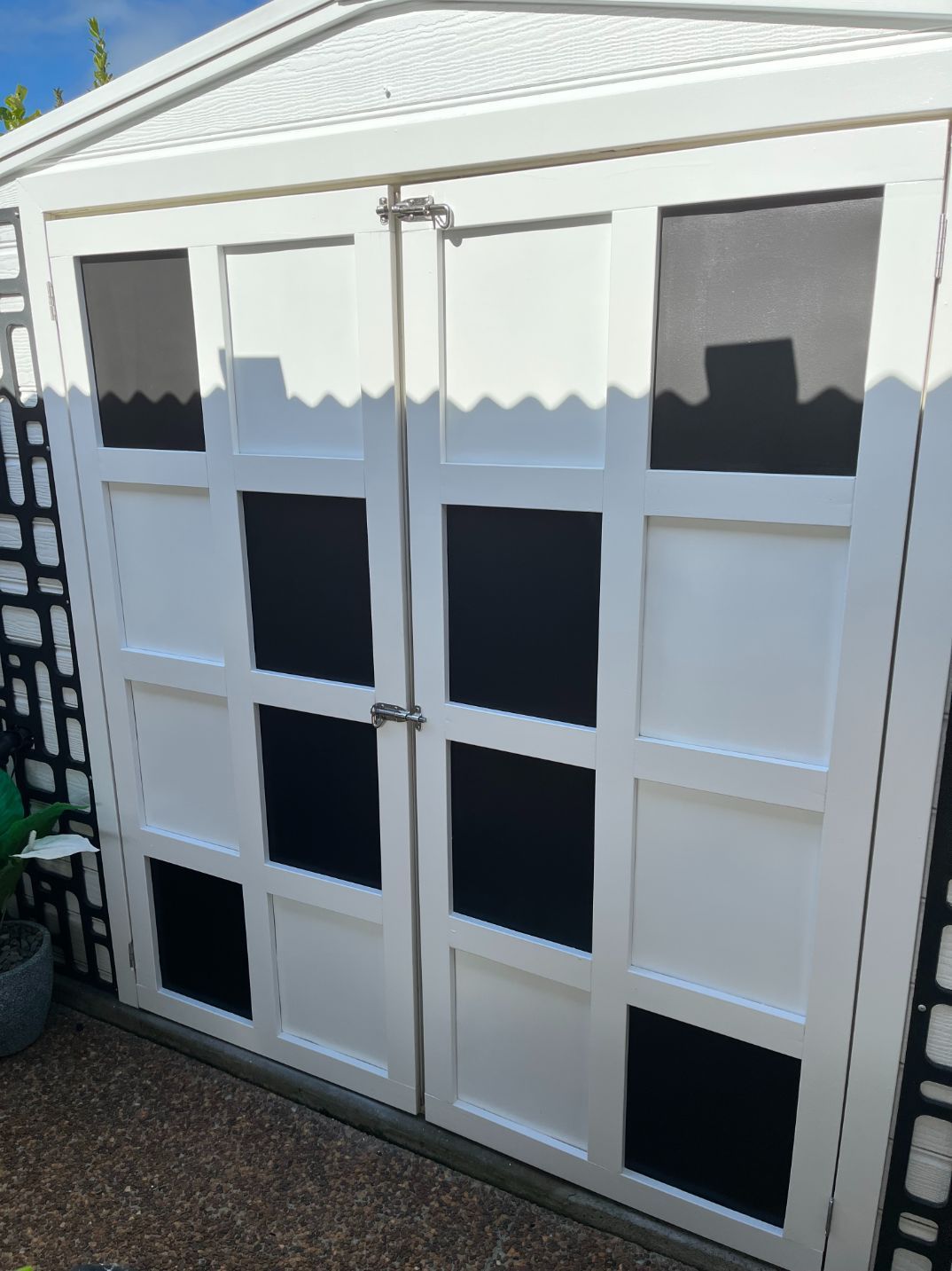 A White Garage Door With Black Squares on It — Holster Painting Contractors In Port Macquarie, NSW