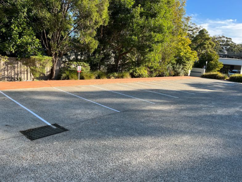 An Empty Parking Lot With Trees in the Background — Holster Painting Contractors In Port Macquarie, NSW