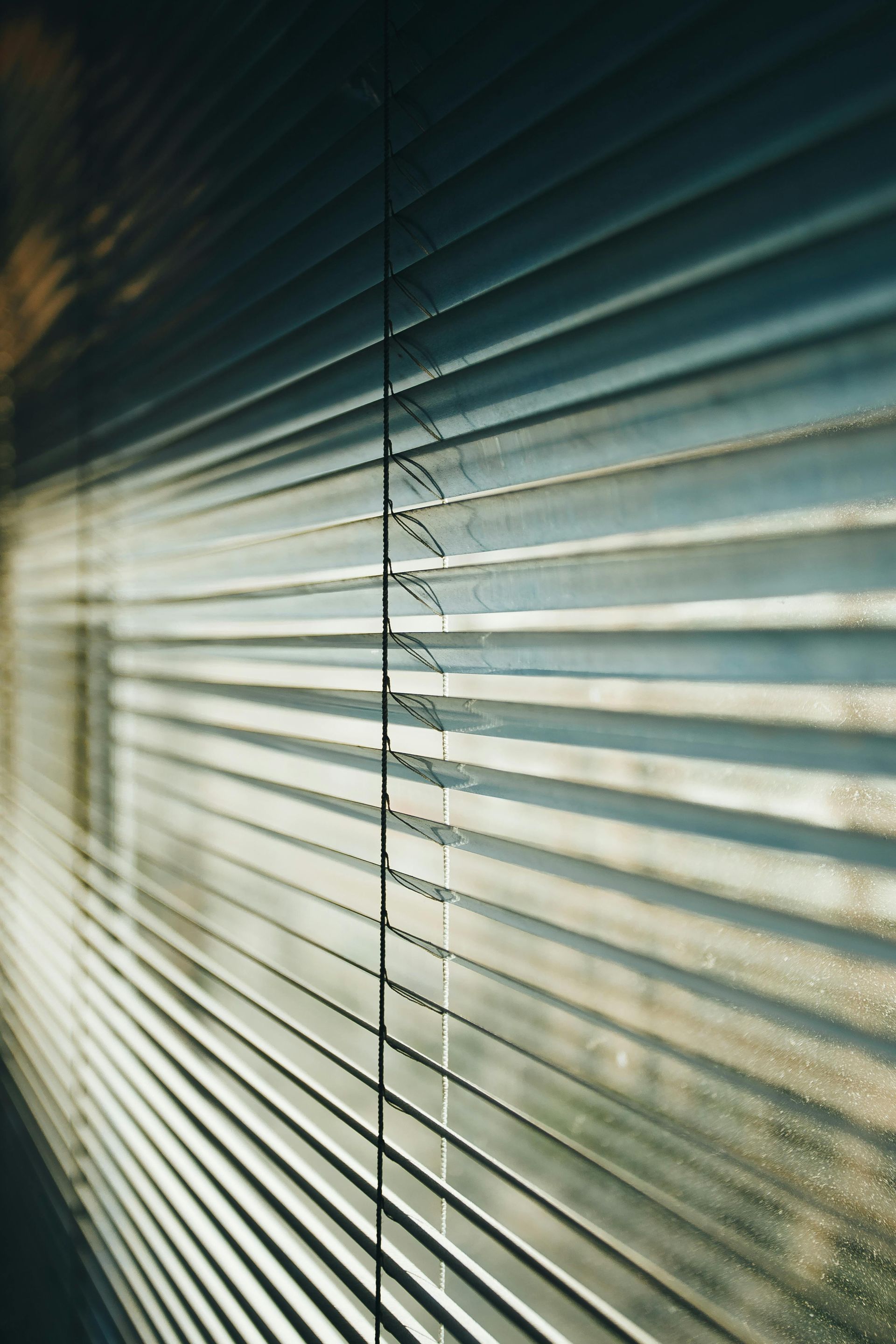A close up of a window with blinds on it.