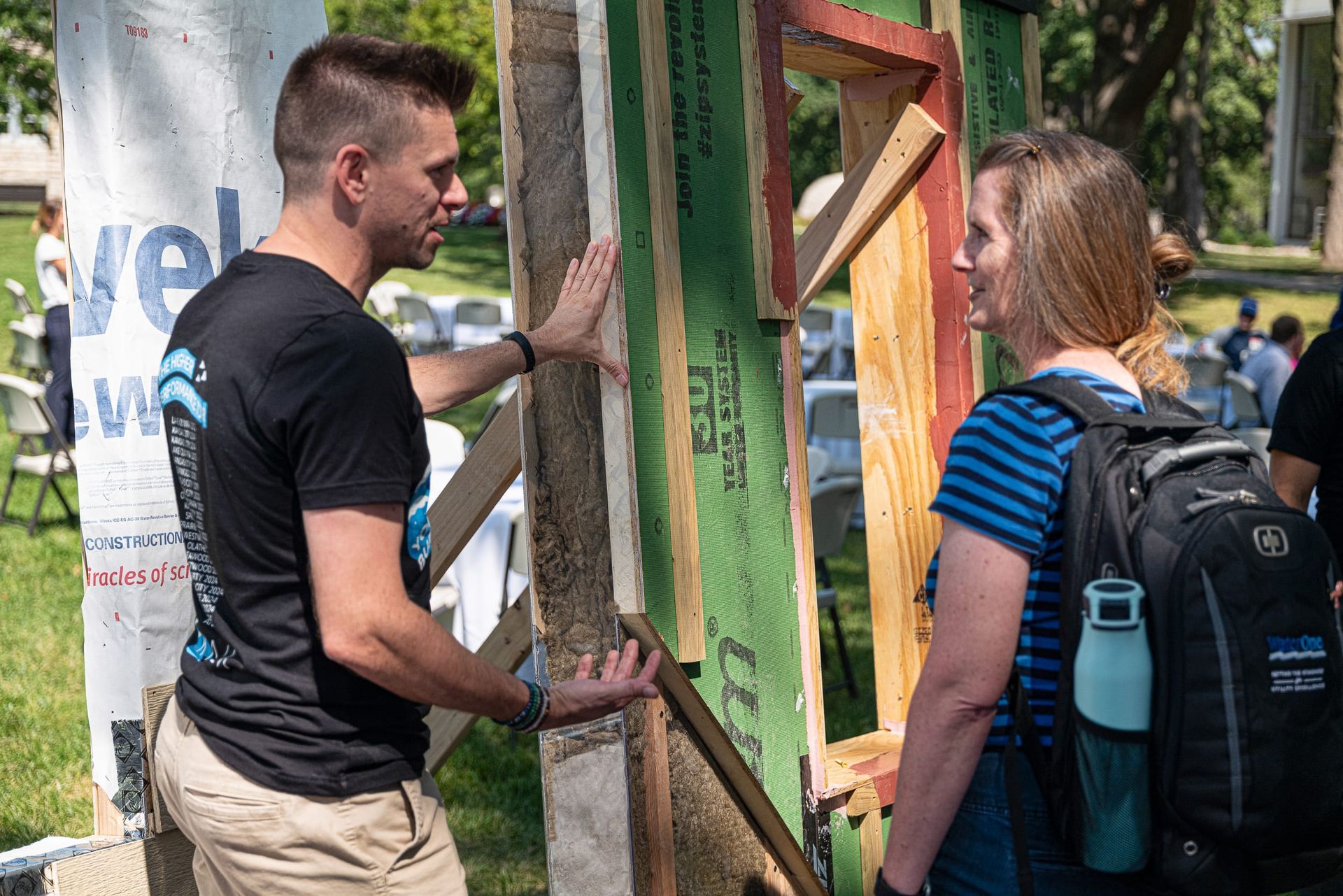 Joe Nickels pointing to a sample wall and explaining the differences between it and a traditional wall