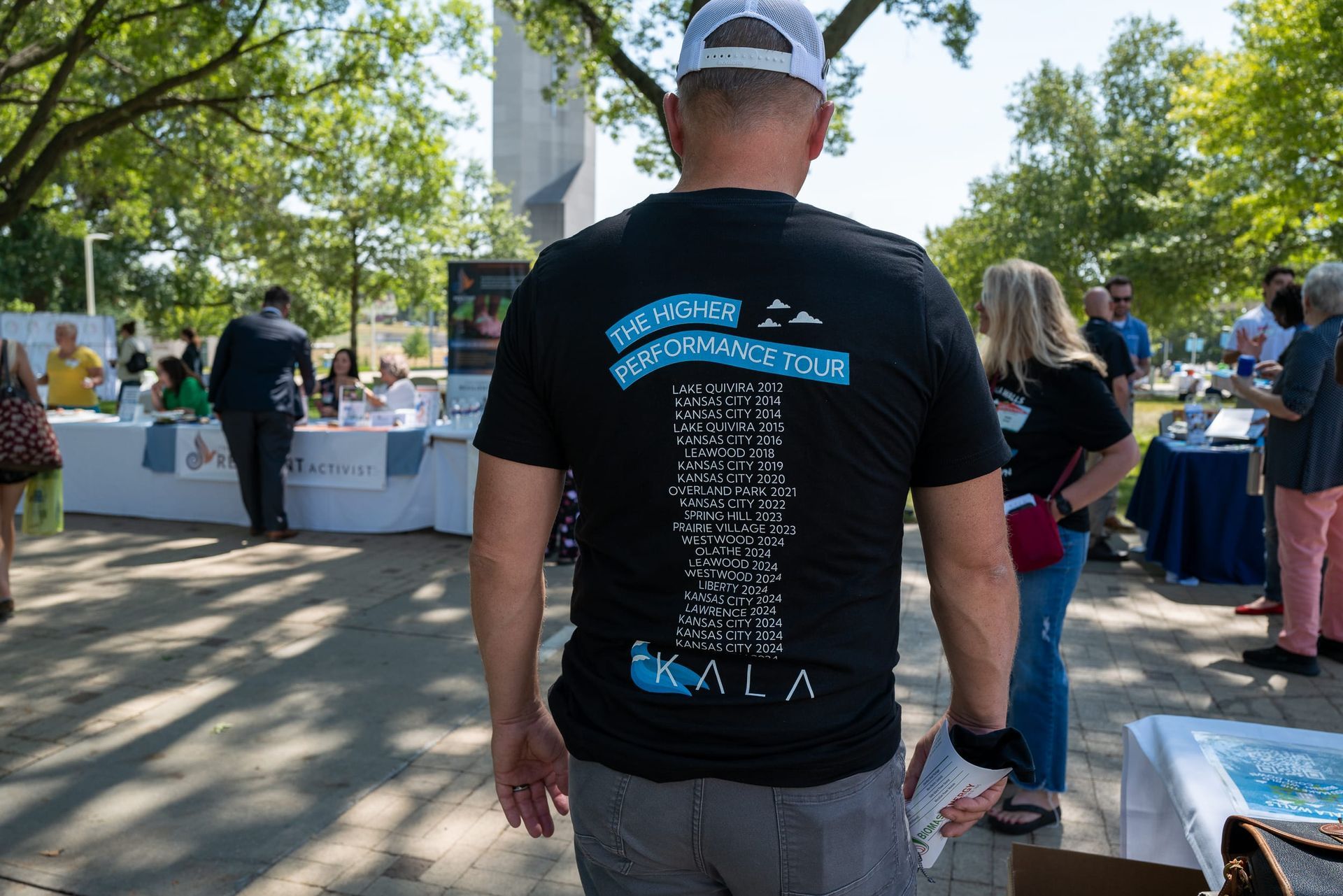 Back of a black shirt listing several homes that Kala has built