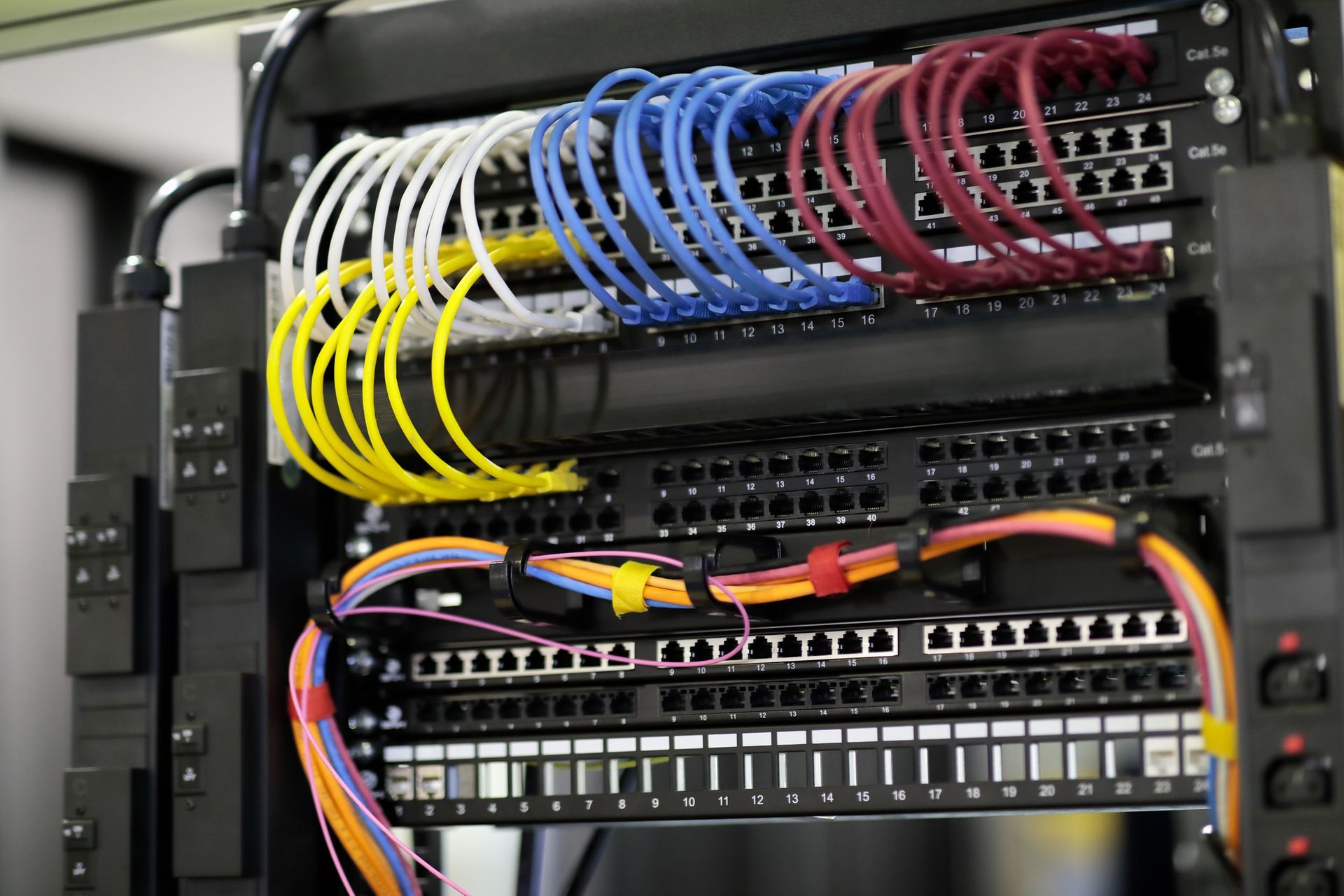 A bunch of wires are connected to a server rack
