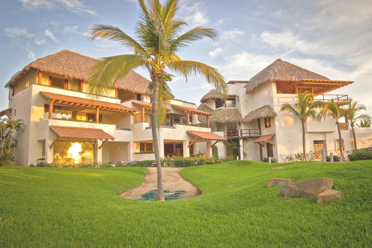 Una casa grande con una palmera delante de ella
