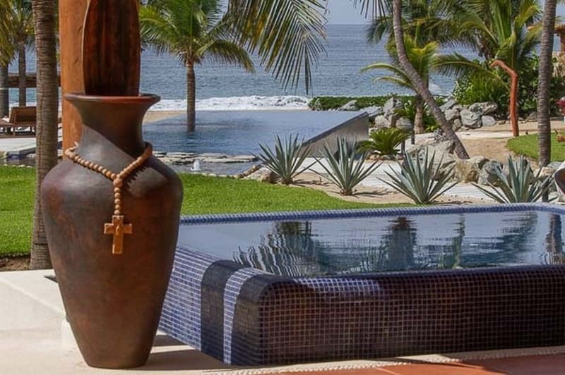 Un gran jarrón con una cruz se encuentra junto a una piscina.