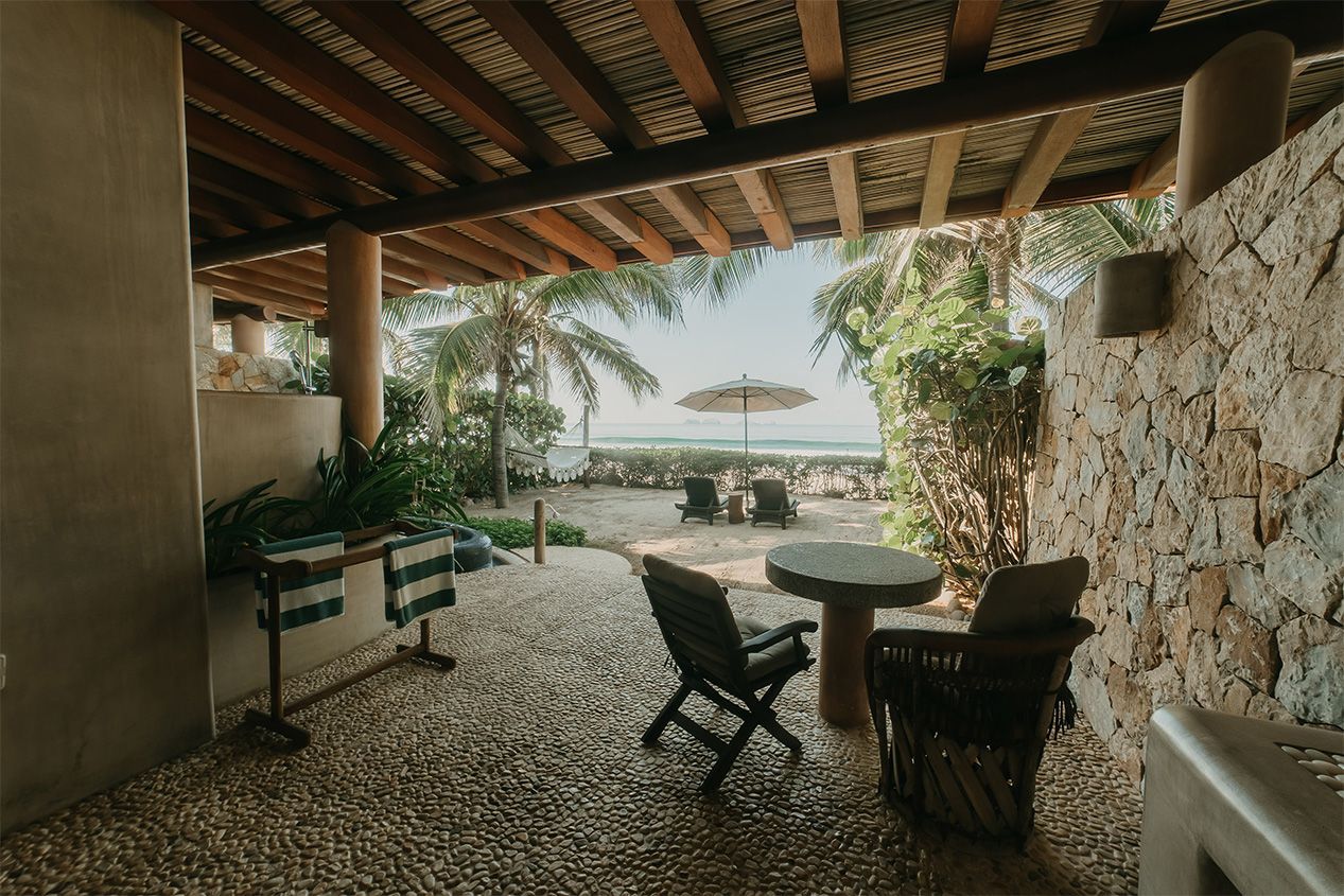 Un patio con mesa y sillas y vista al mar.
