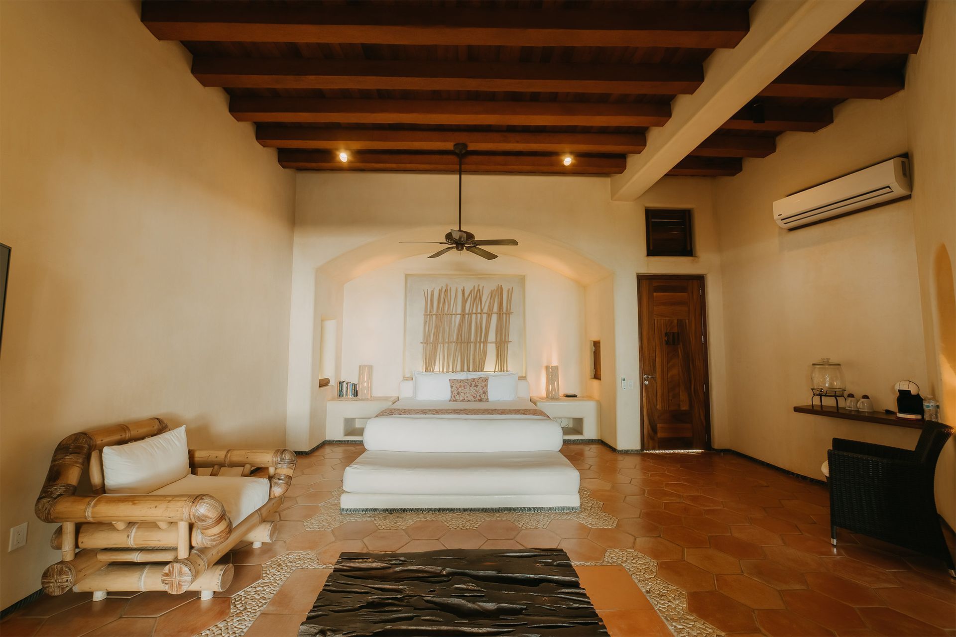 Un dormitorio grande con una cama tamaño king, un sofá y un ventilador de techo.