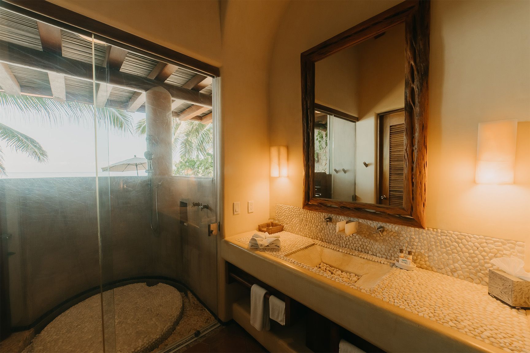Un baño con lavabo, espejo y ducha.
