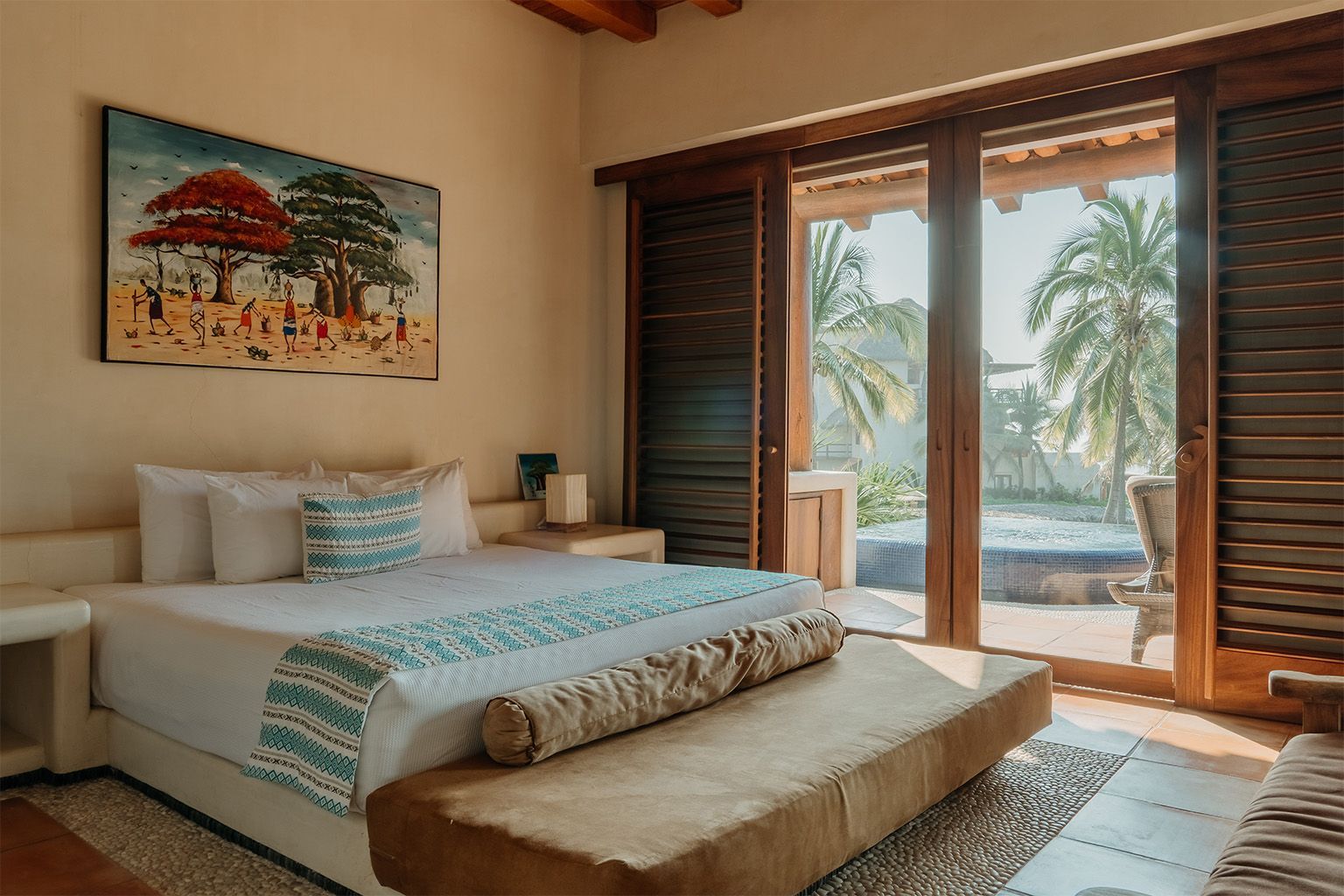 Un dormitorio con una cama grande, puertas corredizas de vidrio y un cuadro en la pared.