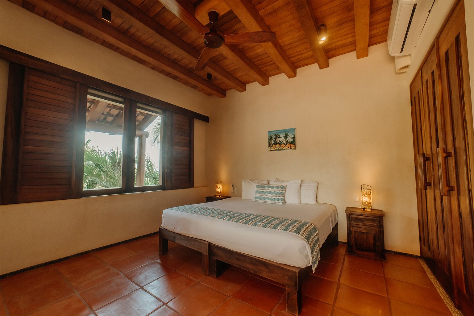 Un dormitorio con una cama king size y un ventilador de techo.