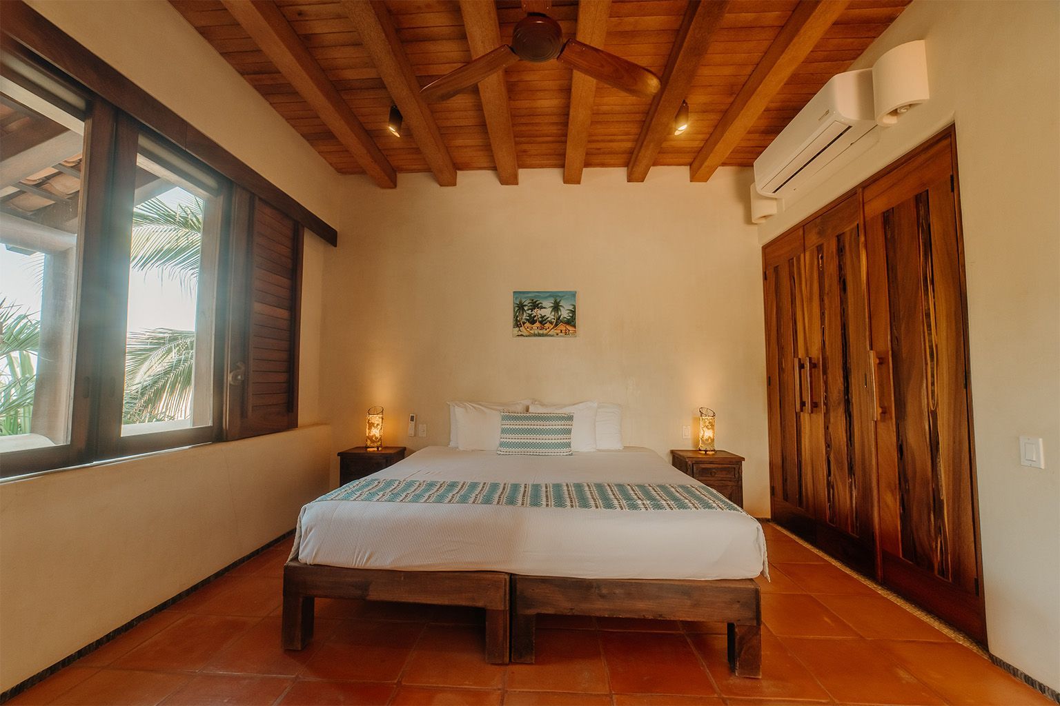 Un dormitorio con una cama king size y un ventilador de techo.
