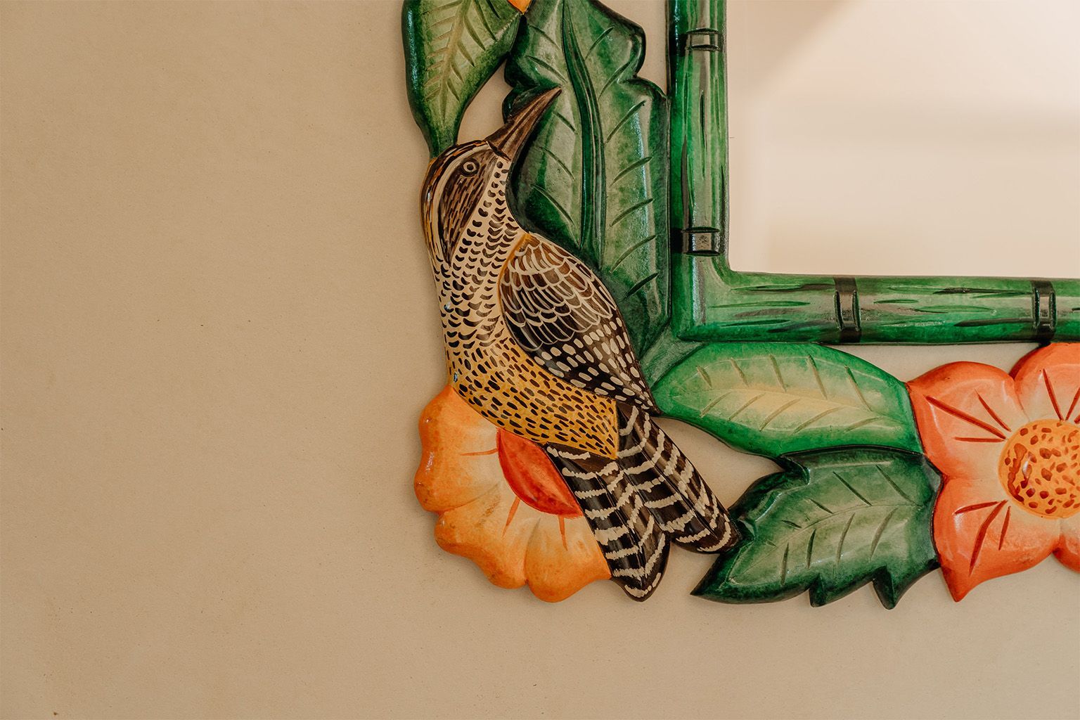 Un espejo con un pájaro y flores.