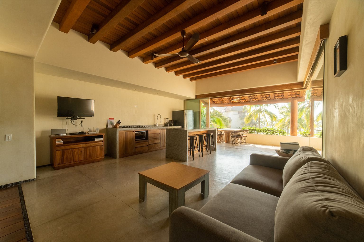 Una sala de estar con sofá, mesa y televisión.