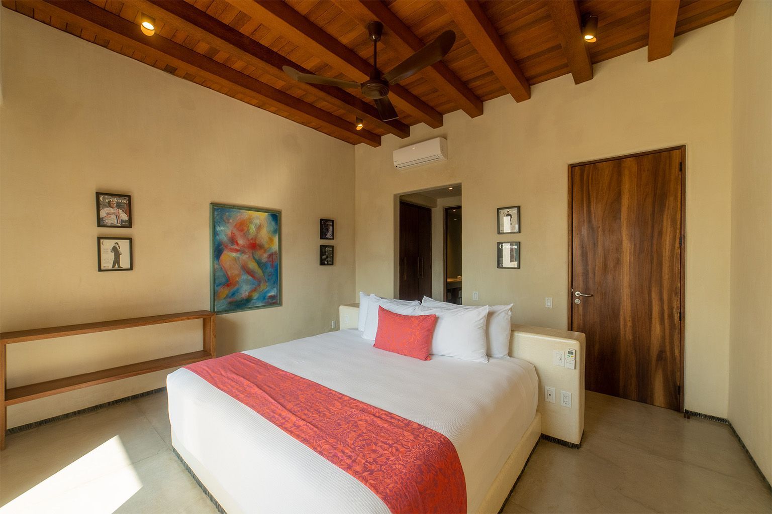 Un dormitorio con una cama king size y un ventilador de techo.