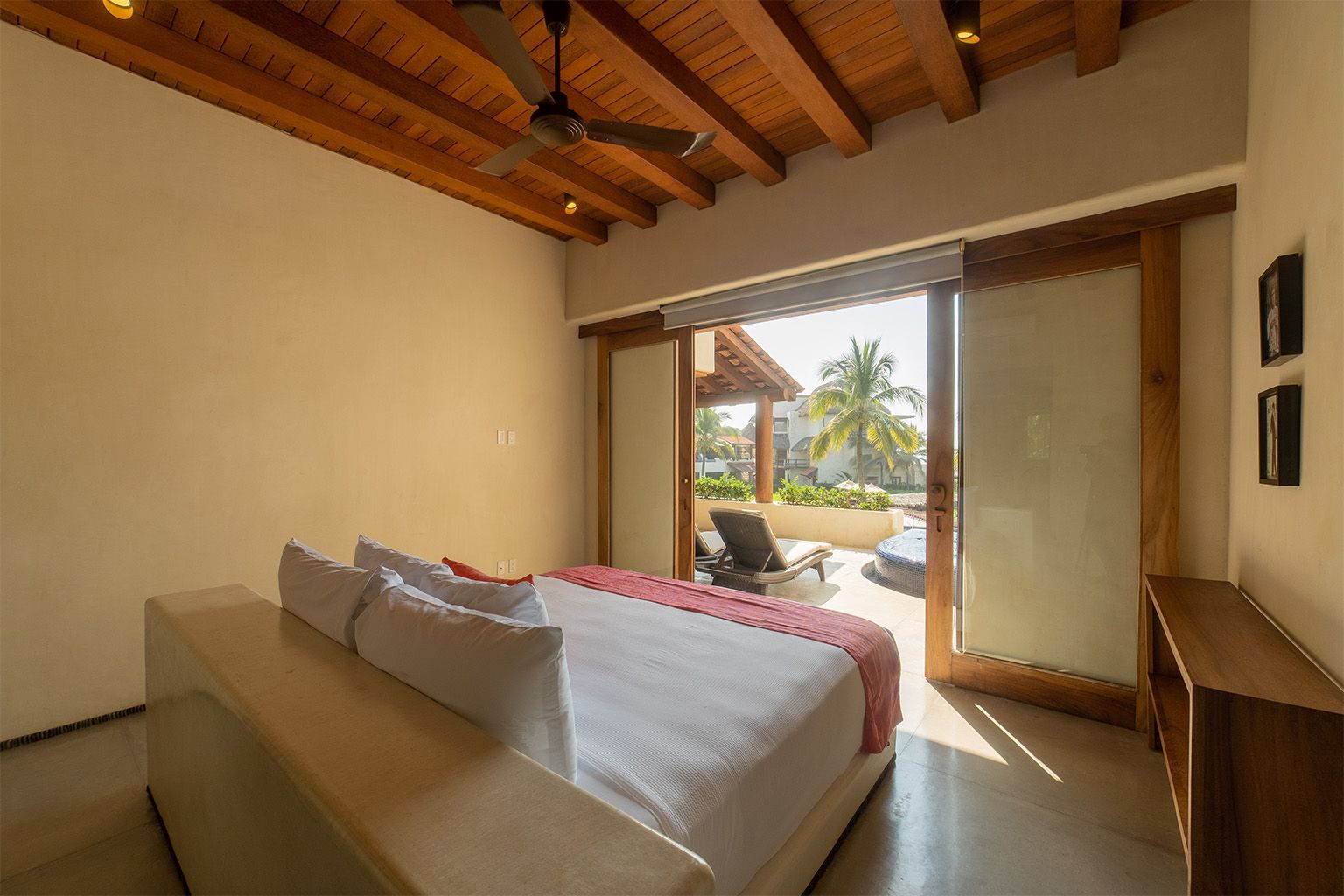 Un dormitorio con una cama tamaño king y una puerta corrediza de vidrio que conduce a un balcón.