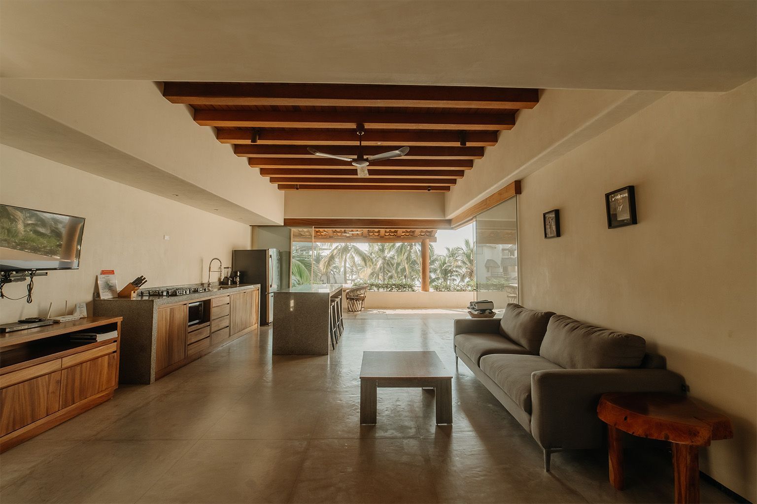 Una sala de estar con sofá, mesa y televisión.